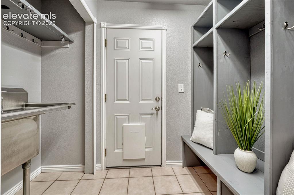 13695 Woodlake Road Elbert, CO 80106 - Photo 25 of 39 fMud room with garage access, stainless steel utility sink and storage.