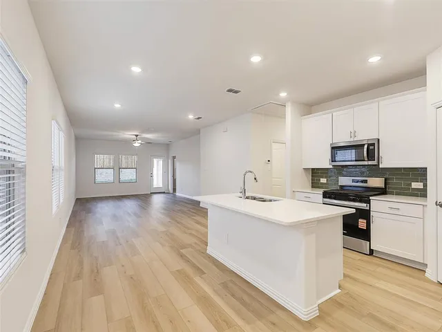 a view of center kitchen island a sink wooden floor and a refrigerator