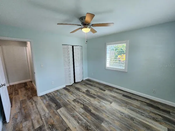 a view of empty room with wooden floor