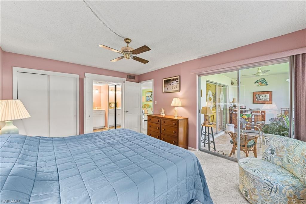 300 Valley Stream Drive, Unit A1 Naples, FL 34113 - Photo 11 of 27 a bedroom with a large bed and a chandelier