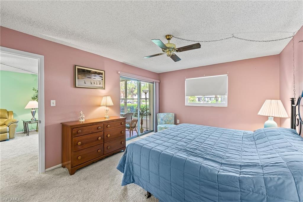 300 Valley Stream Drive, Unit A1 Naples, FL 34113 - Photo 12 of 27 a bedroom with a bed and a dresser