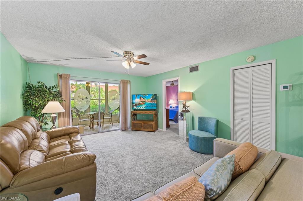 300 Valley Stream Drive, Unit A1 Naples, FL 34113 - Photo 14 of 27 a living room with furniture and a large window
