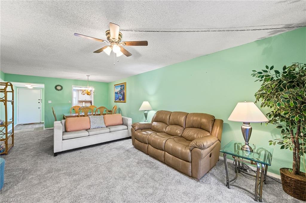 300 Valley Stream Drive, Unit A1 Naples, FL 34113 - Photo 16 of 27 a living room with furniture and a chandelier