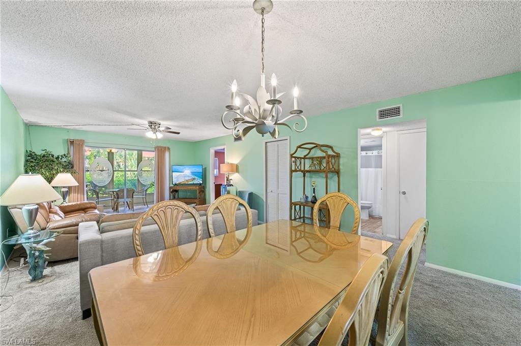 300 Valley Stream Drive, Unit A1 Naples, FL 34113 - Photo 20 of 27 a view of a dining room with furniture and chandelier