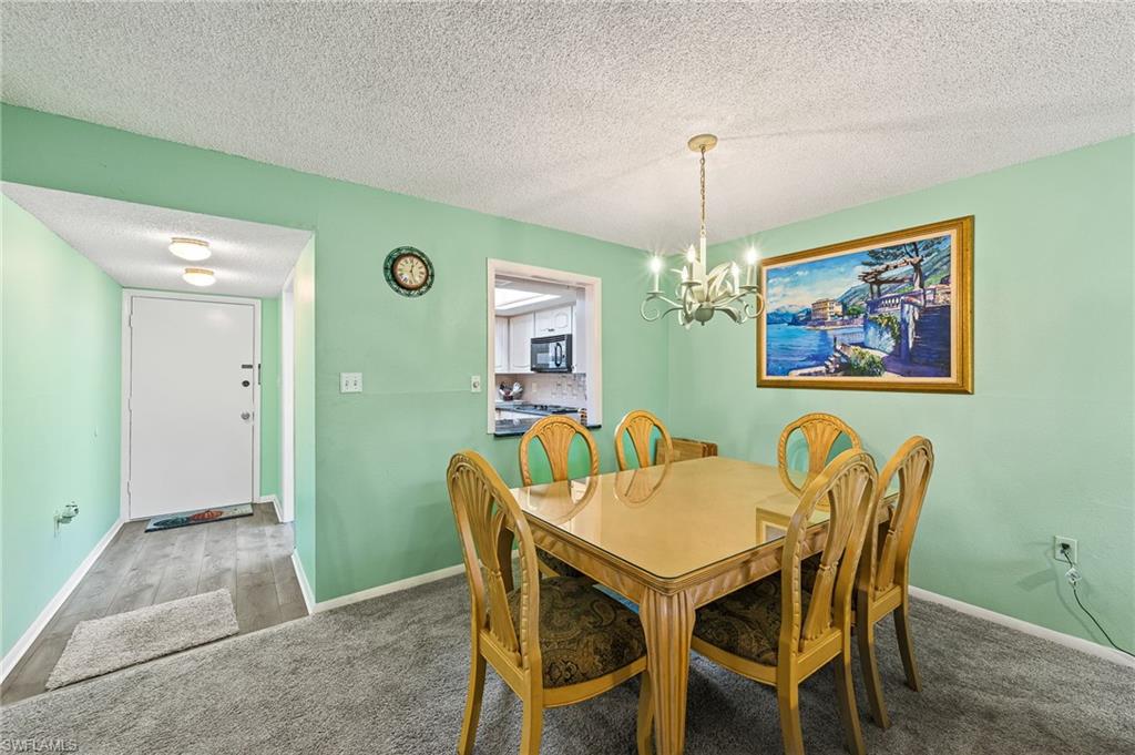 300 Valley Stream Drive, Unit A1 Naples, FL 34113 - Photo 21 of 27 a view of a dining room with furniture and chandelier