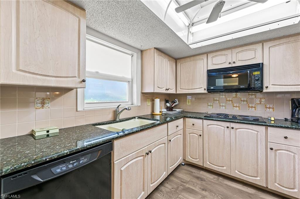 300 Valley Stream Drive, Unit A1 Naples, FL 34113 - Photo 24 of 27 a kitchen with granite countertop a sink stainless steel appliances and cabinets