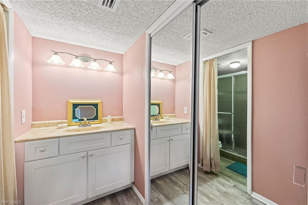 300 Valley Stream Drive, Unit A1 Naples, FL 34113 - Photo 4 of 27 a en suite bathroom with a granite countertop sink and a mirror
