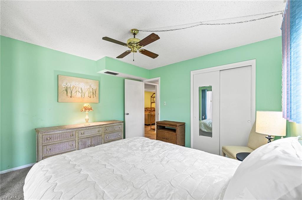 300 Valley Stream Drive, Unit A1 Naples, FL 34113 - Photo 7 of 27 a bedroom with a bed and a chandelier