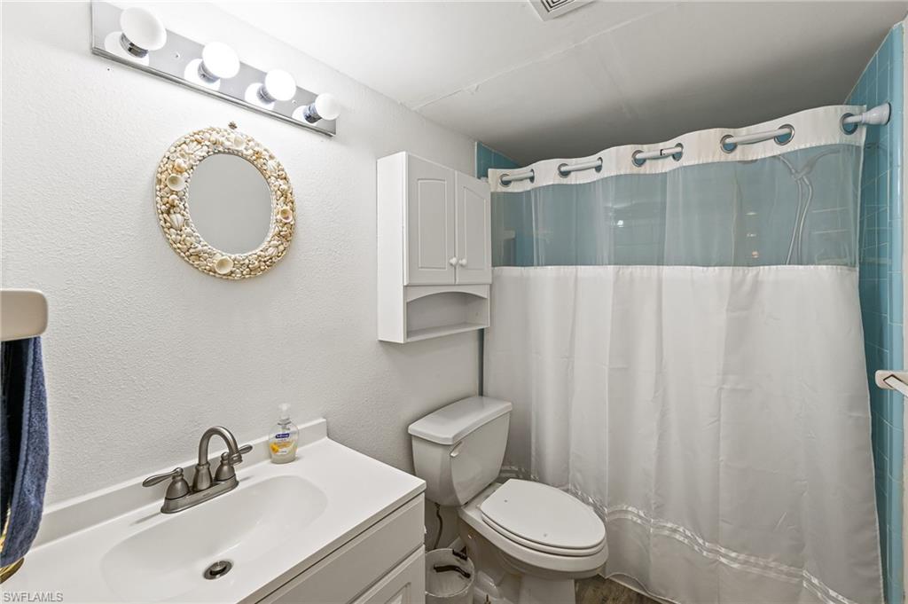300 Valley Stream Drive, Unit A1 Naples, FL 34113 - Photo 8 of 27 a bathroom with a sink mirror vanity and toilet