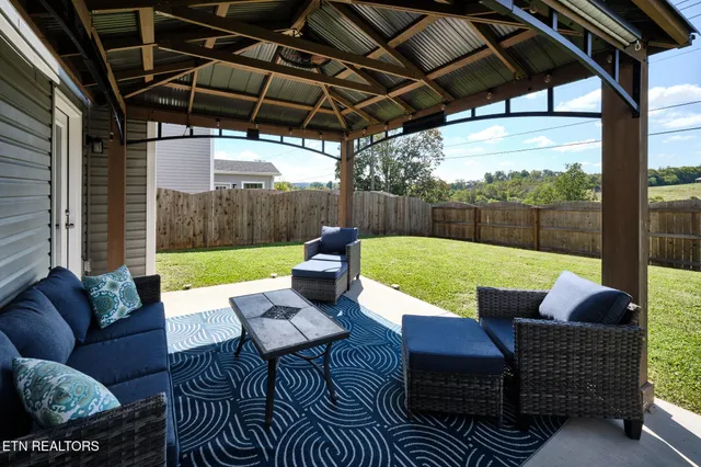 a view of a patio with couches chairs and a big yard