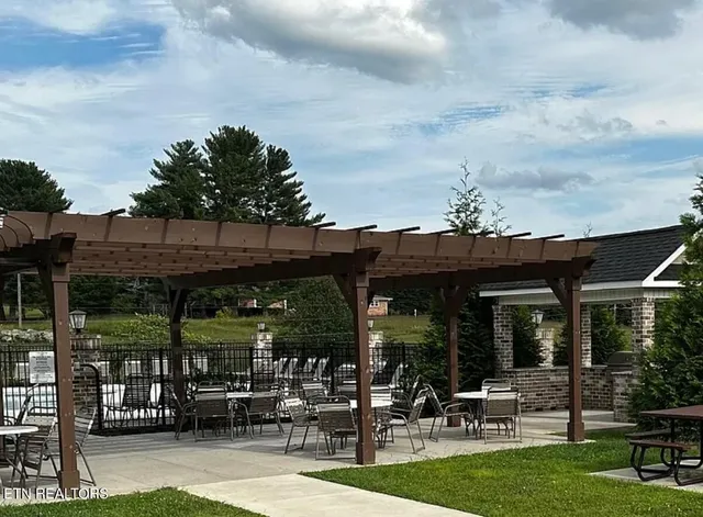 a view of a chairs and table in patio with a yard
