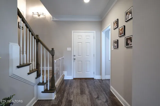 a view of a hallway with wooden floor and entryway