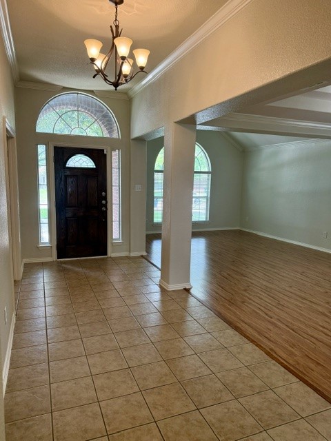 20724 Kearney Hill Road Pflugerville, TX 78660 - Photo 7 of 40 Entryway featuring a dark wood front door with an arched transom window and sidelights, overhead chandelier lighting, and crown molding