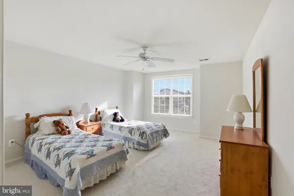 a bedroom with two beds and a chandelier