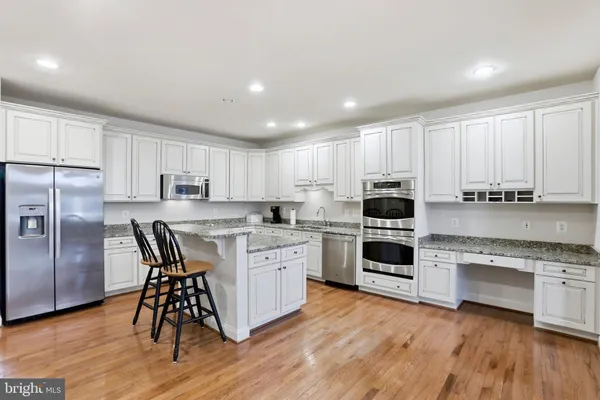 a kitchen with granite countertop white cabinets and stainless steel appliances