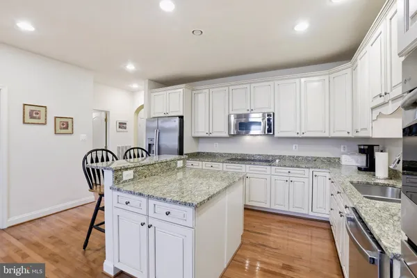 a kitchen with granite countertop sink stainless steel appliances and wooden cabinets