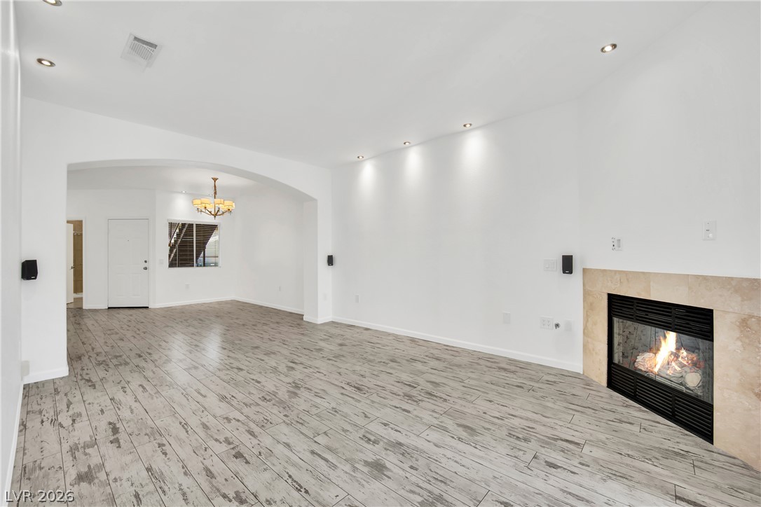 8725 West Flamingo Road, Unit 110 Las Vegas, NV 89147 - Photo 22 of 30 A welcoming living space features distressed wood-look flooring and a cozy fireplace.