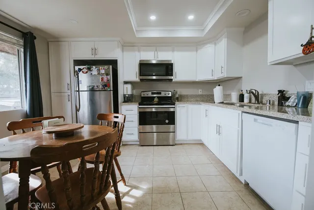 a kitchen with stainless steel appliances granite countertop a refrigerator a stove a sink a microwave and cabinets