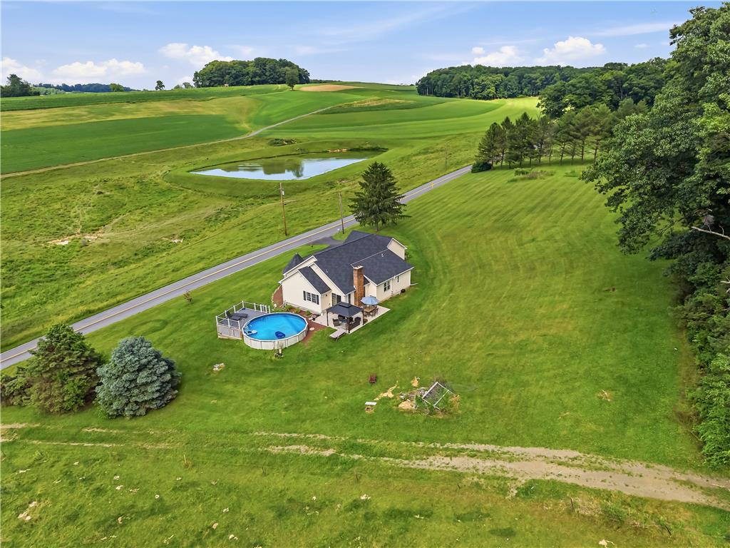9868 Stagecoach Road Kempton, PA 19529 - Photo 4 of 17 Rolling green hills surround this property featuring an inviting above-ground pool and serene pond views.