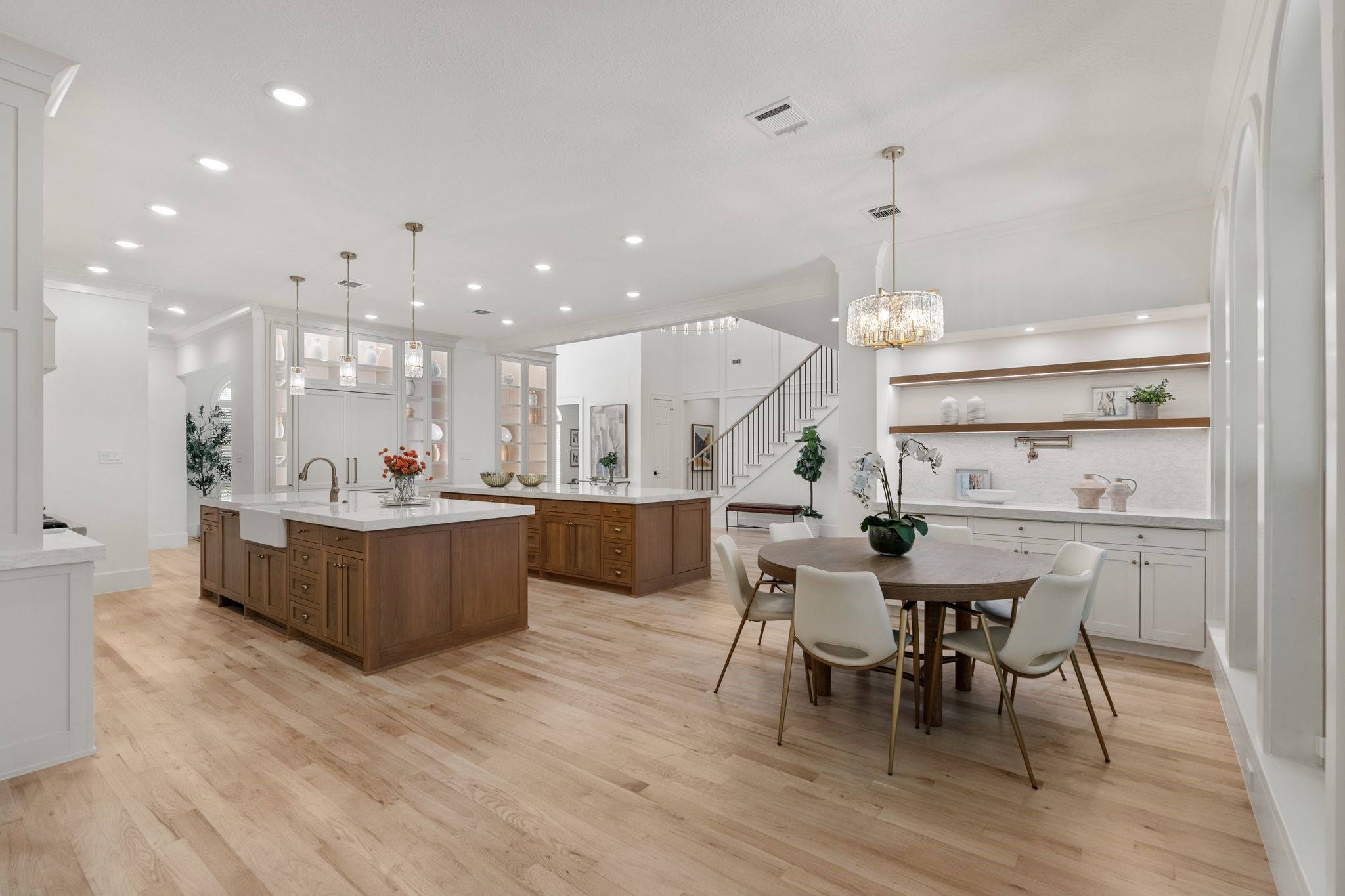 31 Hollymead Drive Spring, TX 77381 - Photo 15 of 50 This open-concept kitchen and dining area features sleek hardwood floors, a spacious island with pendant lighting, and a cozy dining nook. Modern cabinetry and ample natural light enhance the elegant, airy feel.
