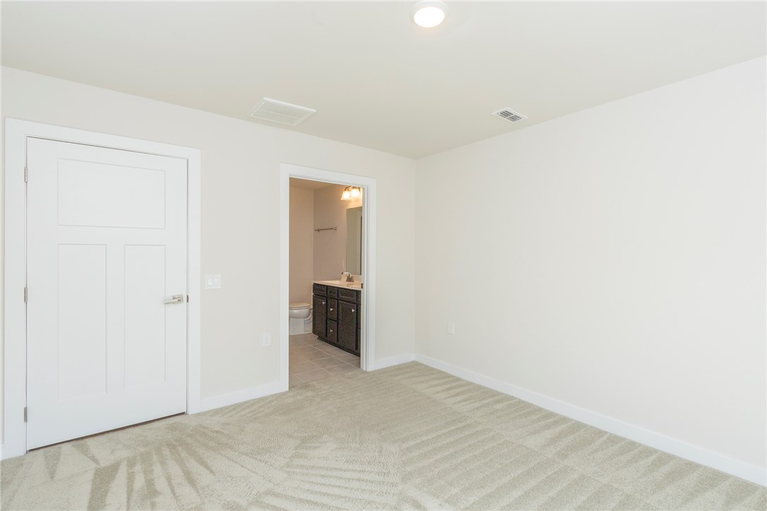 233 Scenic Road Anderson, SC 29621 - Photo 27 of 50 A spacious room offers comfortable carpet flooring and a clear entryway to an adjoining bathroom.