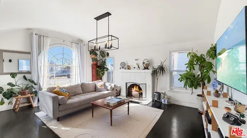 a living room with furniture a chandelier and a fireplace
