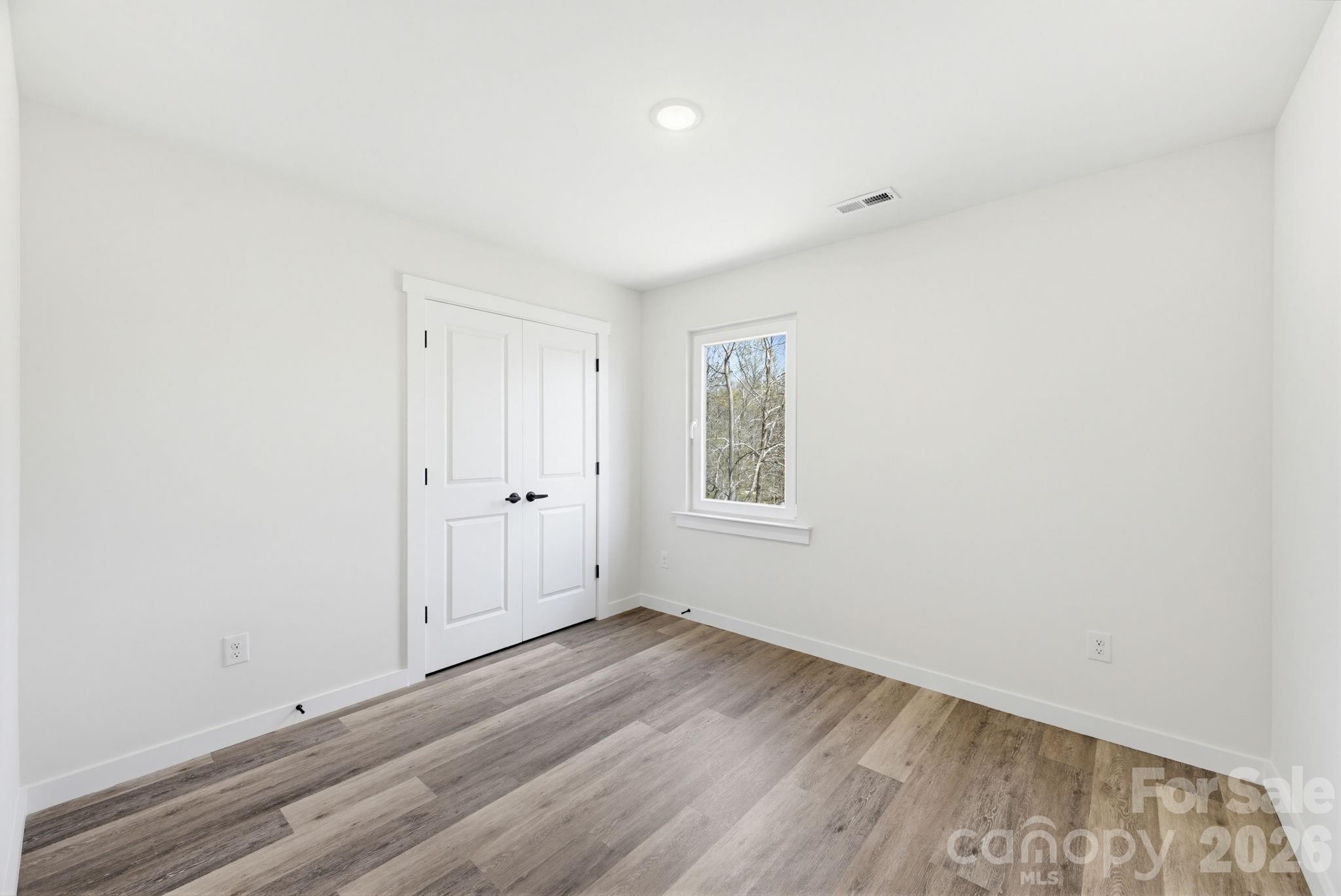 2323 Merts Way, Unit 1 Hudson, NC 28638 - Photo 13 of 15 an empty room with wooden floor and windows