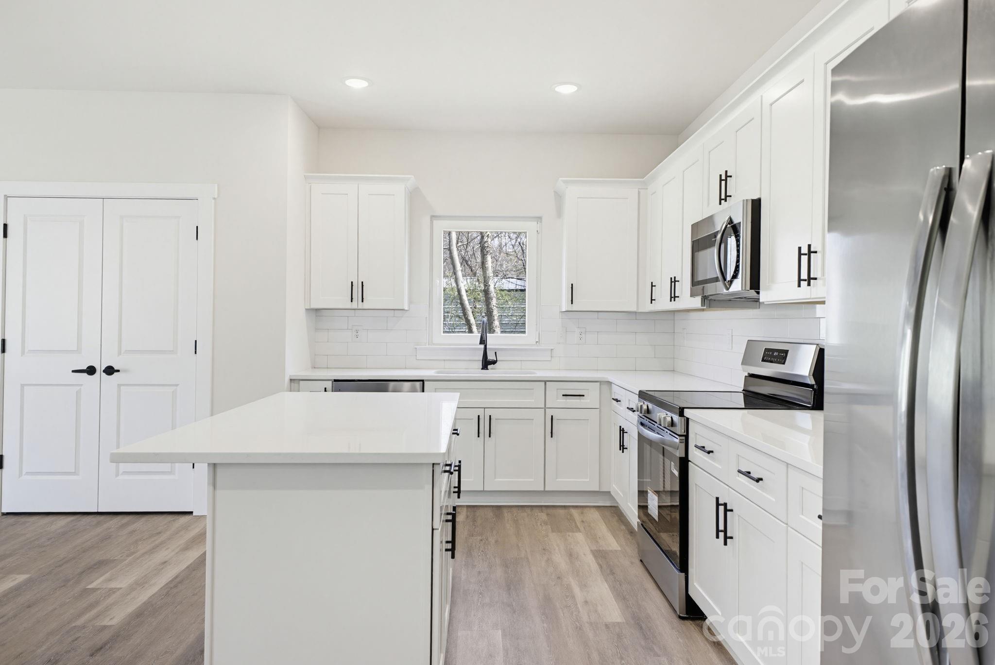 2323 Merts Way, Unit 1 Hudson, NC 28638 - Photo 6 of 15 a kitchen with white cabinets and white appliances