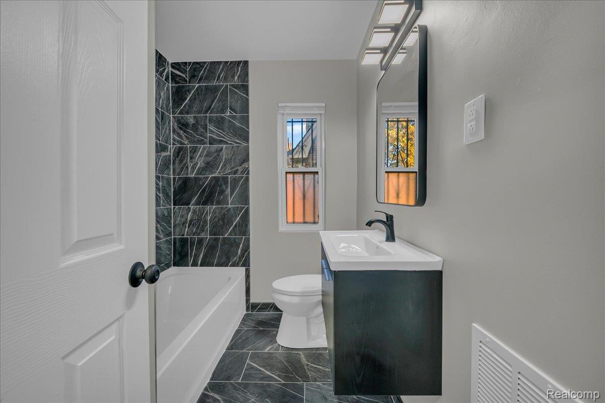 16717 Fielding Street Detroit, MI 48219 - Photo 28 of 46 Full bathroom with vanity, dark marble finish floors, and shower / bathtub combination