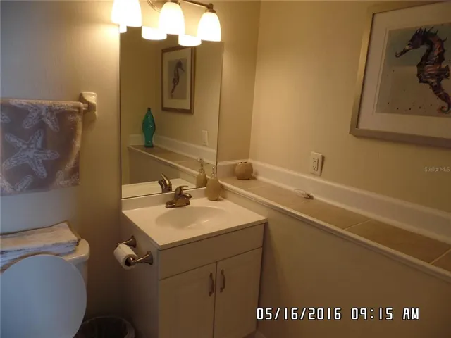 a bathroom with a sink and mirror with toilet