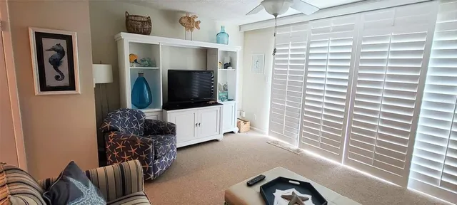a living room with furniture large window and flat screen tv