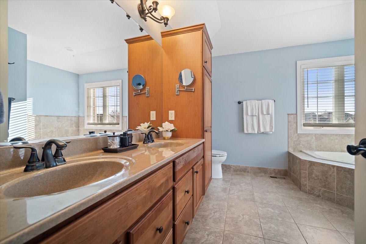 1706 Pfitzer Road Normal, IL 61761 - Photo 18 of 27 a bathroom with a sink a two mirror a bathtub and a toilet