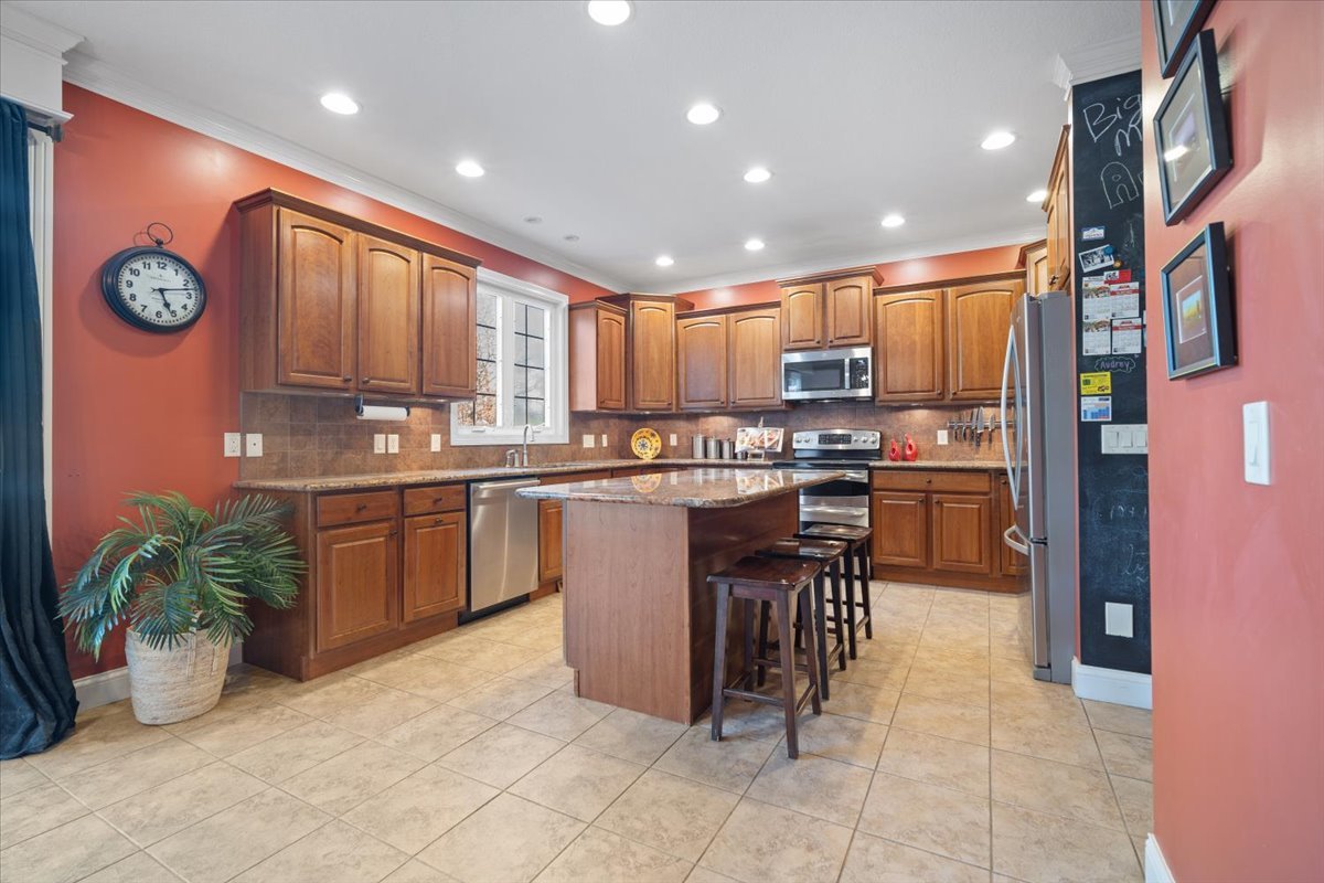 1706 Pfitzer Road Normal, IL 61761 - Photo 8 of 27 a kitchen with stainless steel appliances granite countertop a stove a sink a oven a dining table and chairs