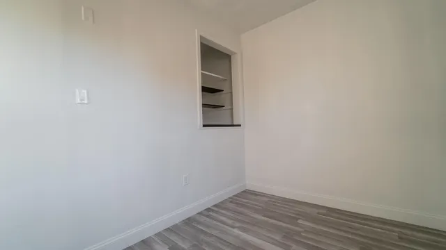 a view of a small space with wooden floor and a window
