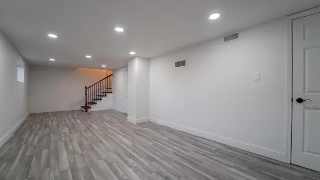 an empty room with wooden floor and entryway
