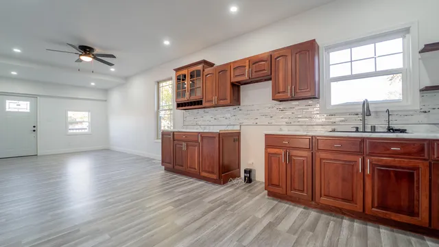 a kitchen with stainless steel appliances granite countertop wooden cabinets a sink and dishwasher with wooden floor