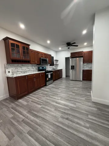 a open kitchen with stainless steel appliances granite countertop a stove and a sink