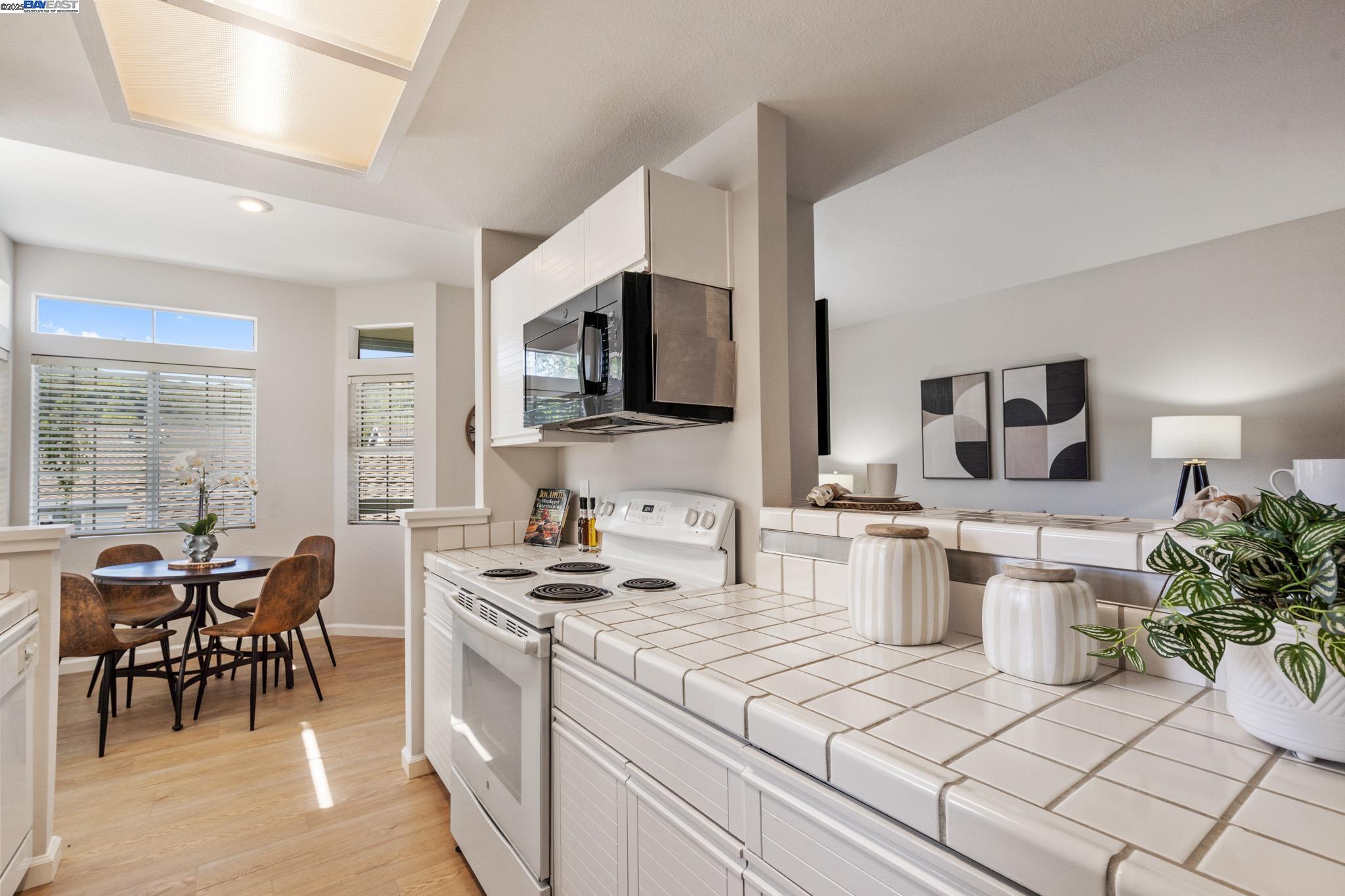 8165 Mountain View Drive, Unit C Pleasanton, CA 94588 - Photo 14 of 35 a kitchen with a stove a sink a microwave and dining table