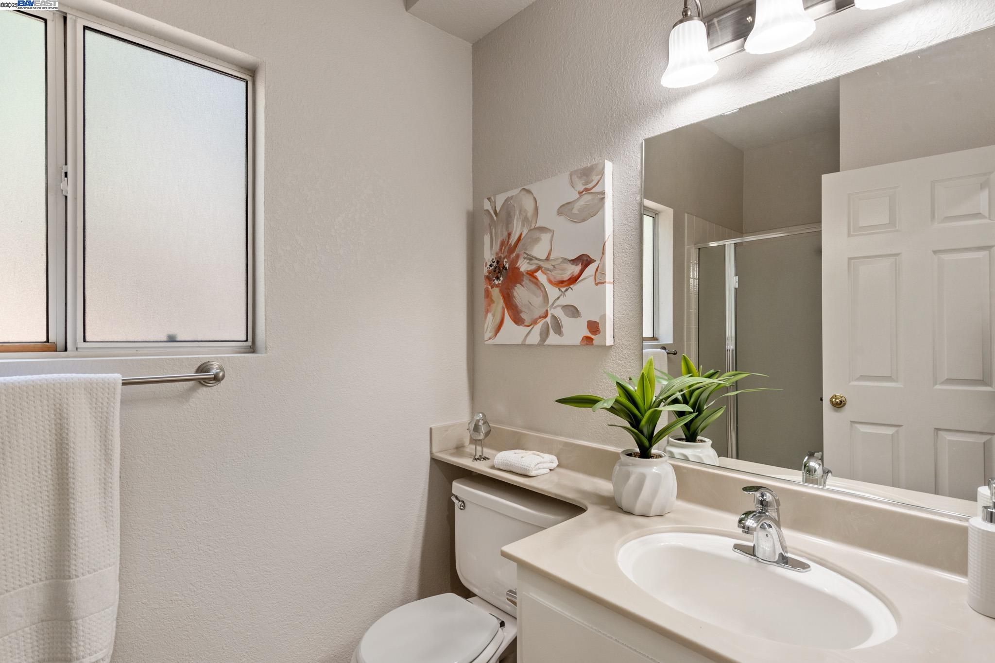 8165 Mountain View Drive, Unit C Pleasanton, CA 94588 - Photo 26 of 35 a bathroom with a toilet sink and mirror