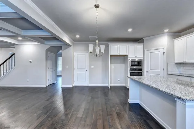 a kitchen with stainless steel appliances granite countertop a refrigerator a sink and wooden floors