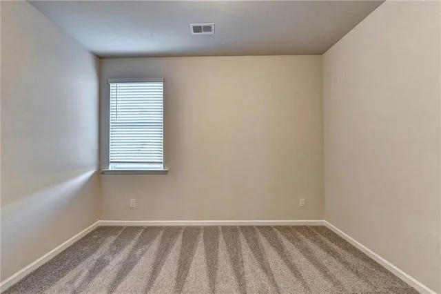 an empty room with white walls and a window