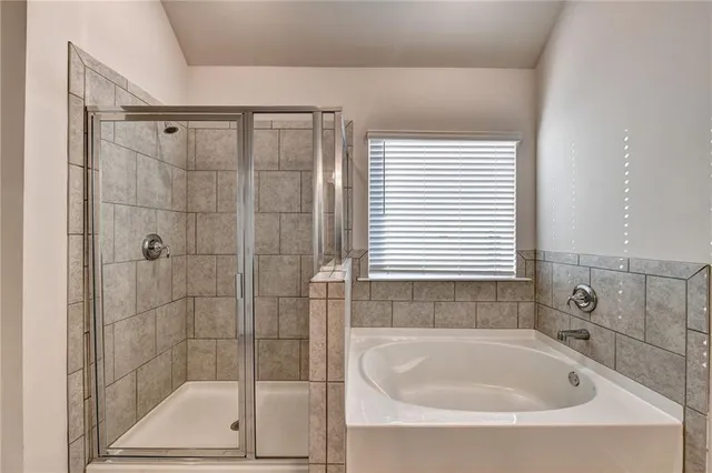a white bath tub sitting next to a shower
