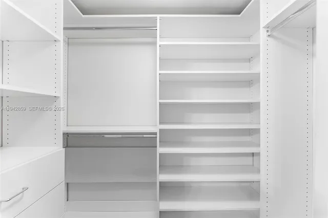 a view of walk in closet with empty racks