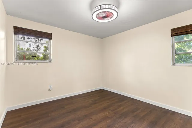 a view of a room with wooden floor and window