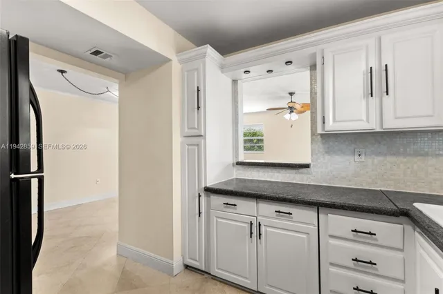 a kitchen with stainless steel appliances white cabinets and a refrigerator