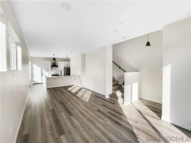 a view of a living room hardwood floor and a kitchen