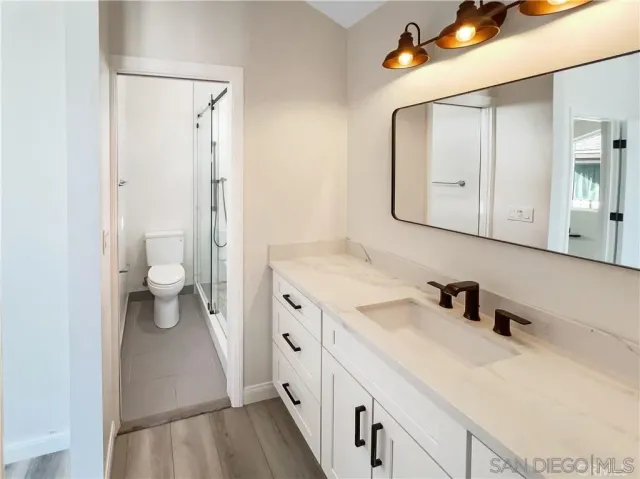 a bathroom with a sink a toilet and a mirror