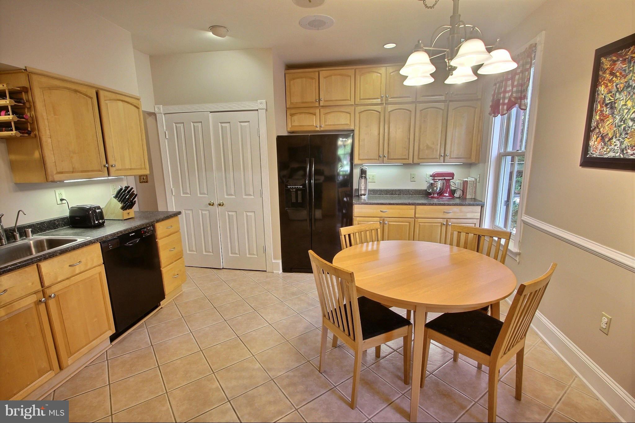 21404 Laytonsville Road Gaithersburg, MD 20882 - Photo 10 of 30 a kitchen with a table chairs refrigerator and microwave