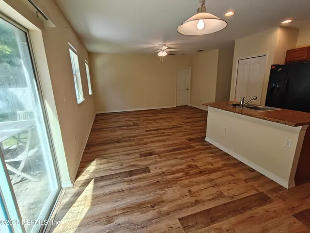 a view of a hallway with wooden floor and staircase