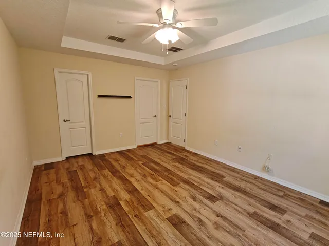 a view of empty room with wooden floor